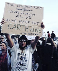 a man holding a sign that says the golden rule