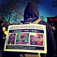 a man with a backpack holding a sign